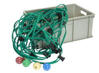 Grünes Illu-Lichterketten-Kabel mit schwarzen Fassungen und bunte Glühbirnen in Rot, Grün, Gelb und Blau vor einer grauen Transportbox, freigestellt auf weißem Hintergrund.